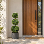 Artificial three ball boxwood topiary in a decorative planter beside a front door