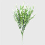 Artificial green plant with white flowers on a light gray background