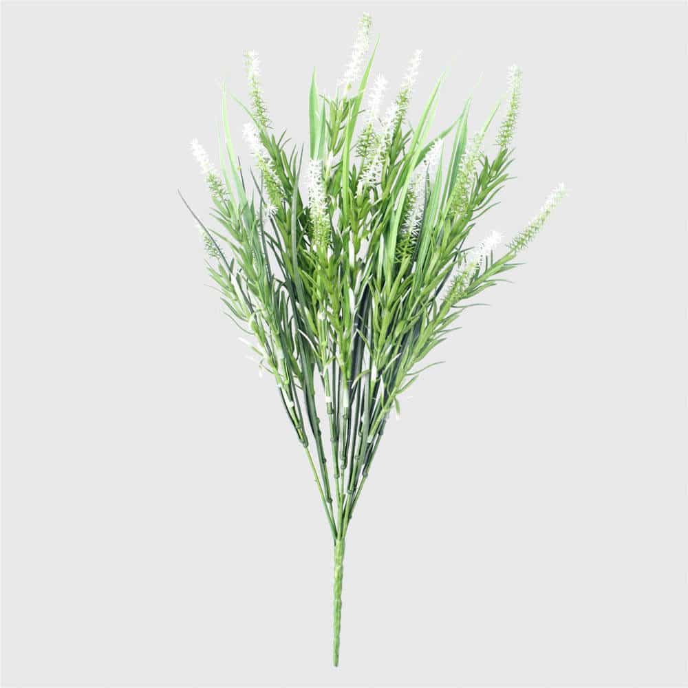 Artificial green plant with white flowers on a light gray background