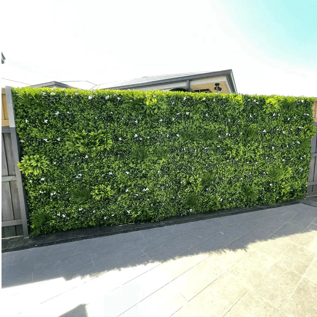 Large outdoor installation of the Group 1 Fire Certified Luxury White Lily artificial green wall providing a premium UV-resistant privacy screen and decorative feature wall.