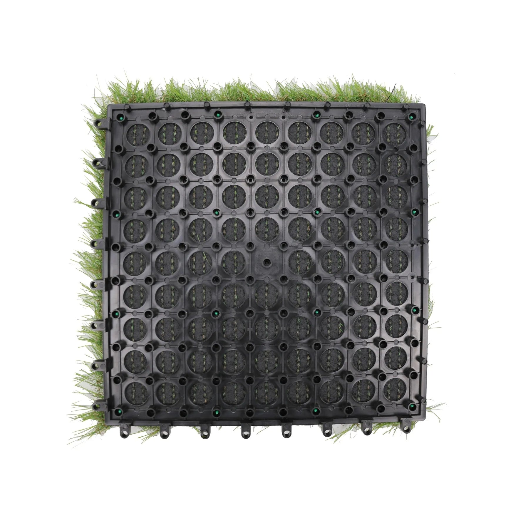 A square black plastic modular pond liner or drainage mat with circular perforations, shown from above on a white background with green grass-like material visible around the edges.