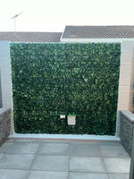 Artificial green wall panel on a building exterior