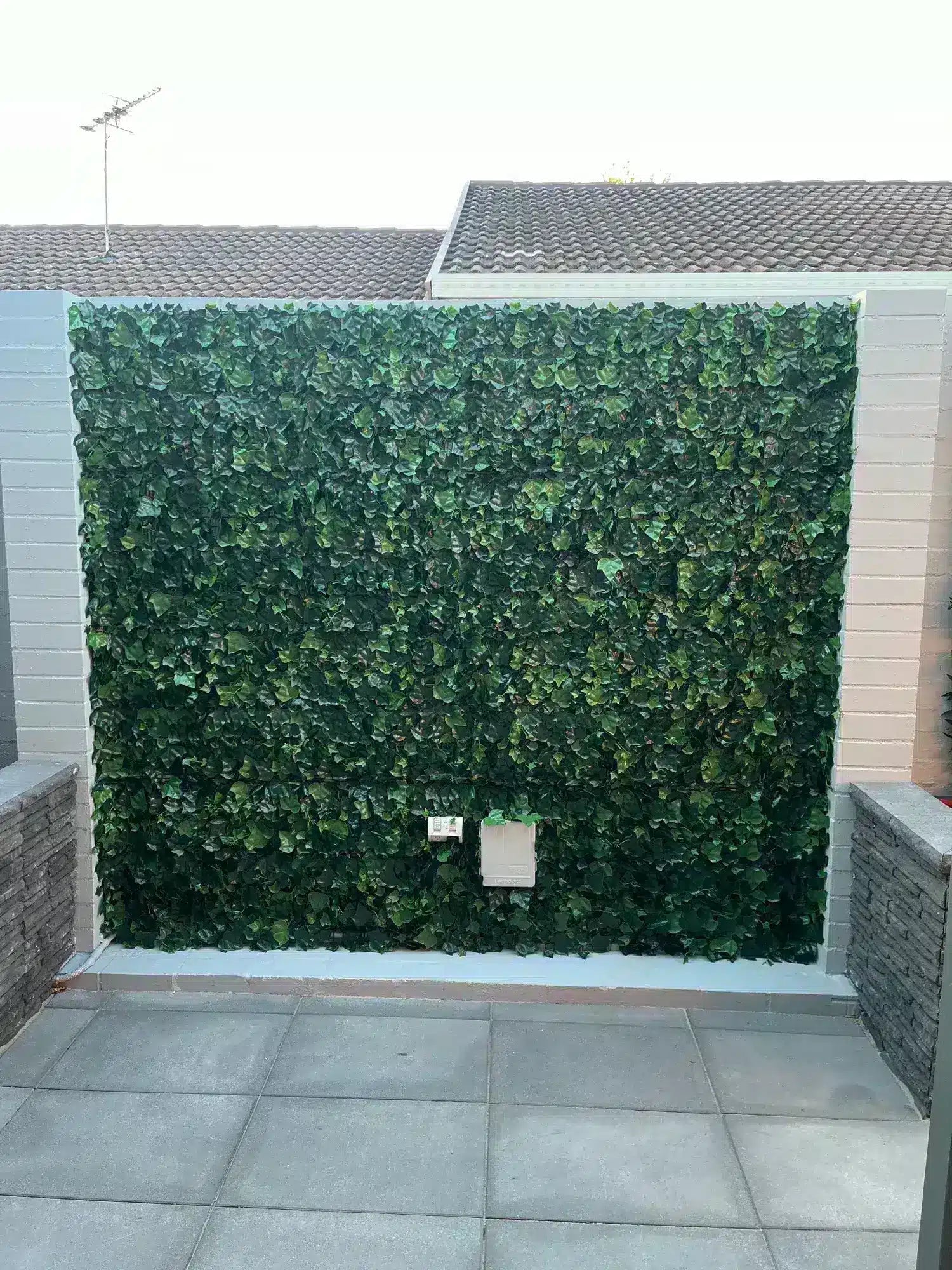 Artificial green wall panel on a building exterior