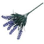 Bouquet of artificial lavender flowers with green leaves on a white background