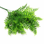 Artificial green leaf branch on a white background