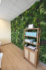 Wooden shelf against a living wall with greenery in an indoor setting