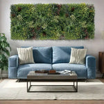 Blue sofa with decorative pillows in a living room setting with a green wall art piece.