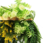 Artificial greenery with a gold frame on a white background