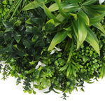 Artificial greenery with various types of leaves on a white background
