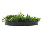 Artificial green grass in a black planter on a white background