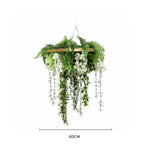 Hanging artificial plant with green leaves and white flowers on a white background