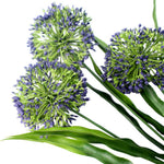 Three artificial allium flowers with green stems and purple buds on a white background