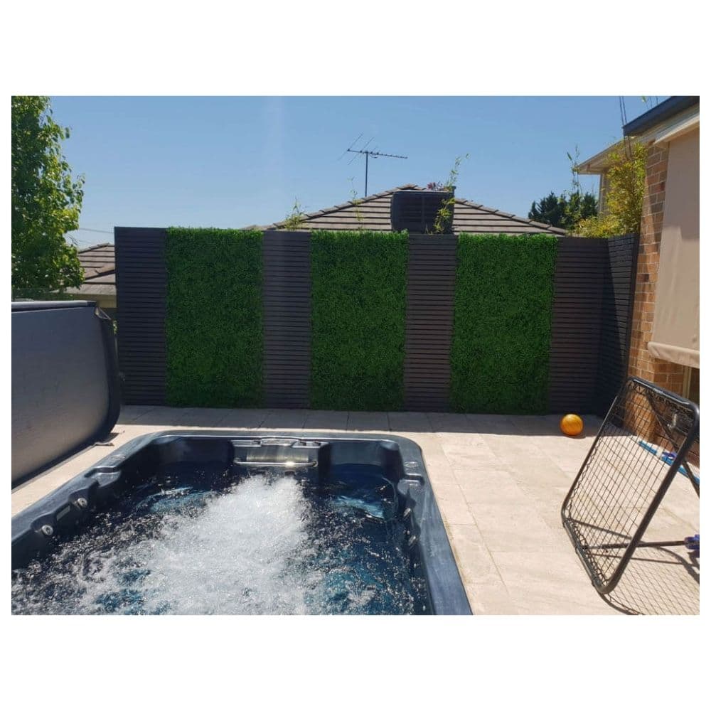Hot tub in a backyard with a privacy screen and outdoor furniture.