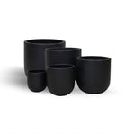 Set of five black ceramic planters of different sizes on a white background