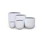 Set of five white ceramic pots of varying sizes on a white background