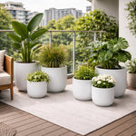 Potted plants on a balcony with a cityscape in the background