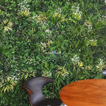 Artificial green wall with a chair and table in front