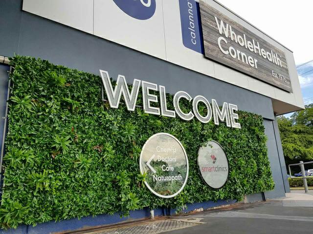 Building exterior with green wall and 'WholeHealth Corner' sign