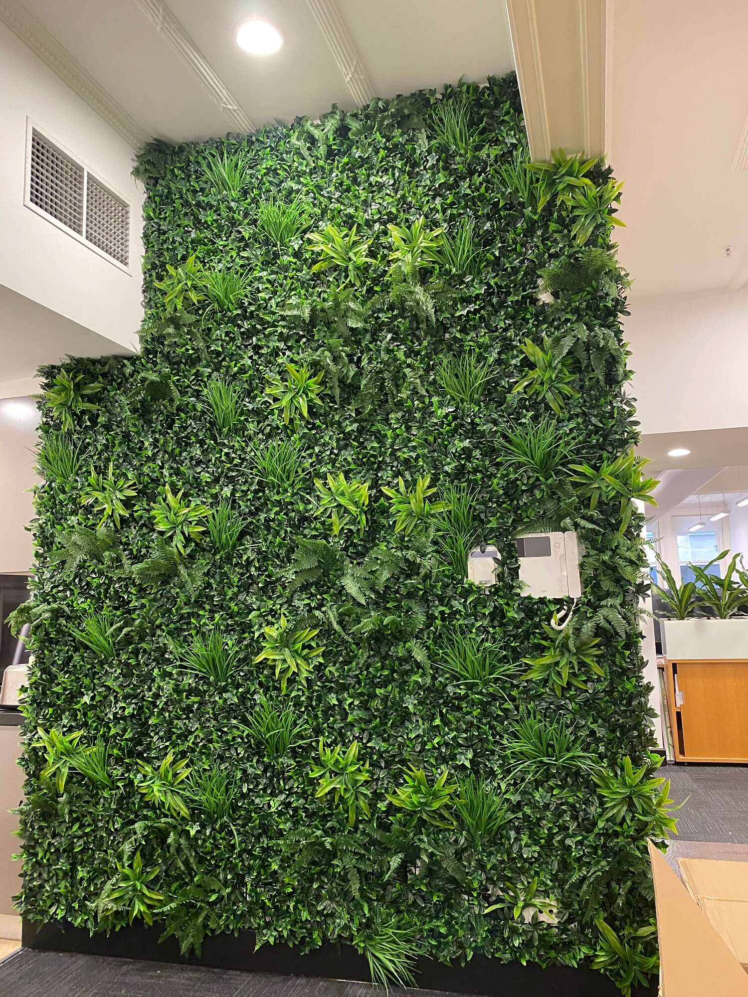 Green artificial plant wall in an indoor setting