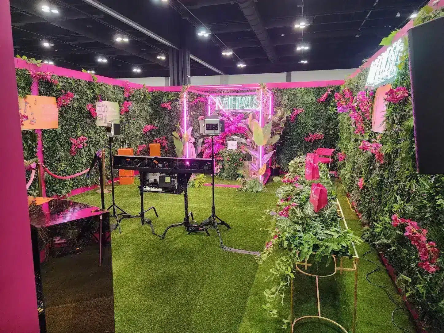 Decorative indoor setting with pink walls, greenery, and electronic equipment.