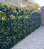Green artificial hedge against a building exterior