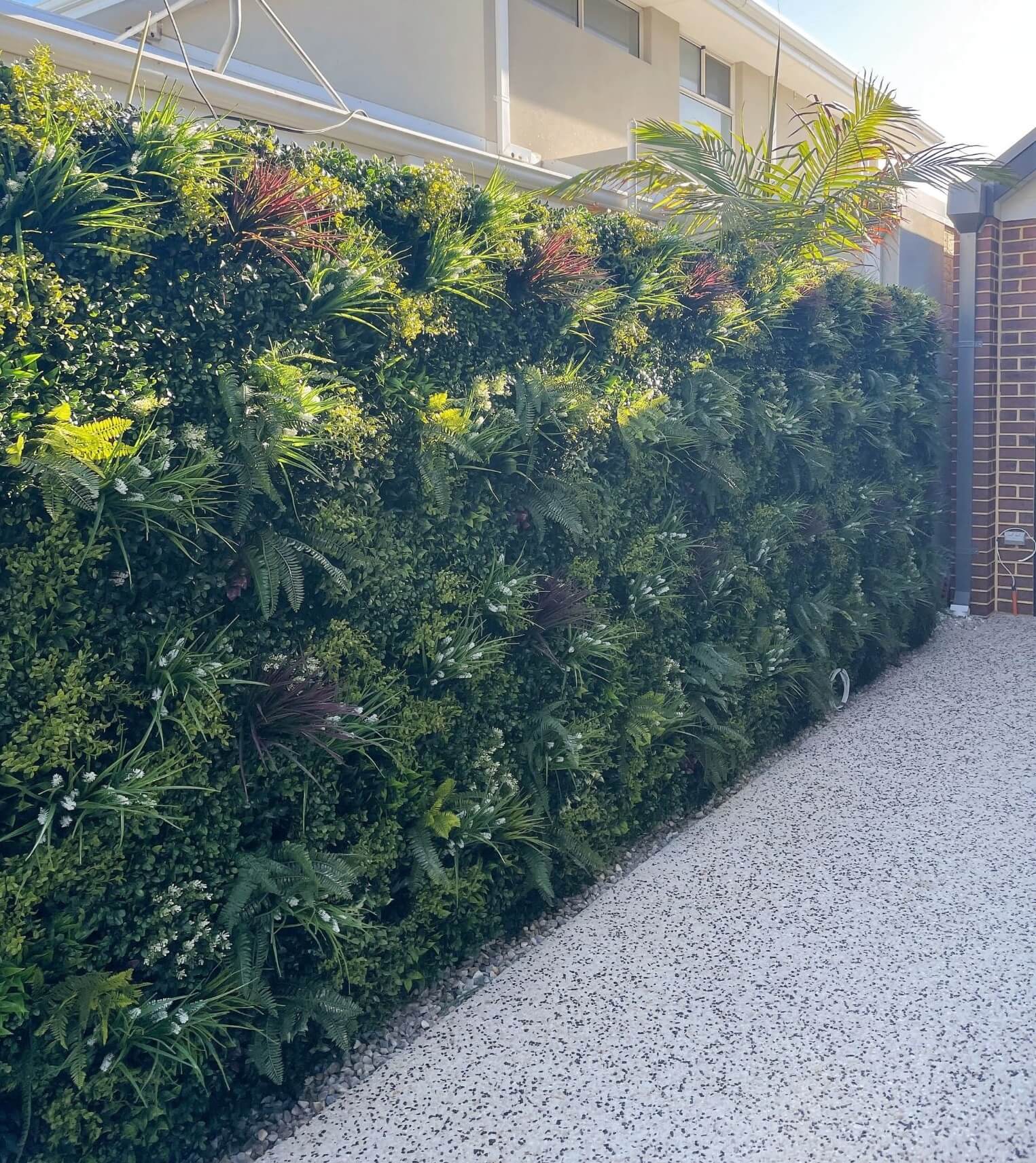 Green artificial hedge against a building exterior