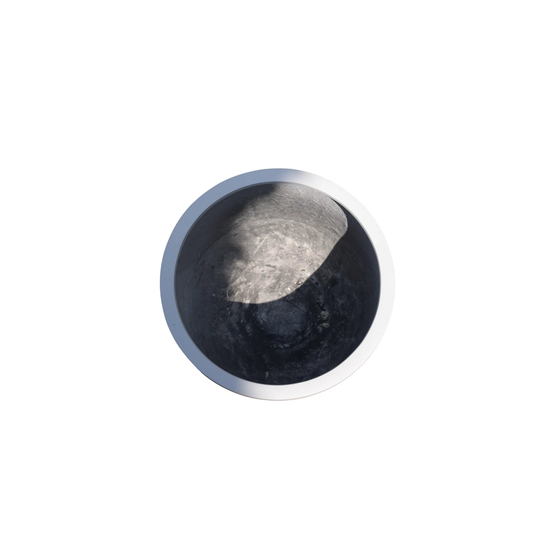 Round metallic object with two-tone finish on a white background