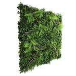 Artificial green wall panel with various green plants on a white background