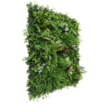 Artificial green wall with various plants on a white background