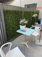 Outdoor patio area with a small table, chairs, and potted plants.