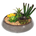 Faux succulent plants in a decorative pot with pebbles on a white background