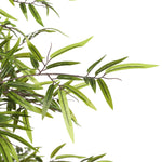 Artificial bamboo branch with green leaves on a white background