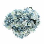 Heart-shaped arrangement of light blue and white flowers on a white background