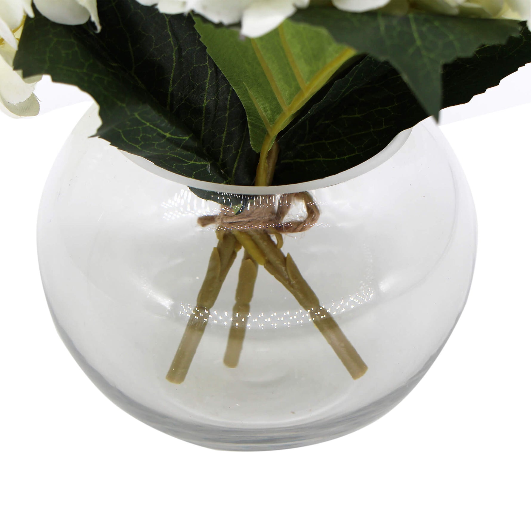 Clear glass vase with decorative sticks and greenery on a white background