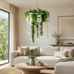 Living room with a white sofa, decorative plants, and a large window.