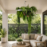 Outdoor living space with a sectional sofa, potted plants, and hanging ferns.