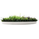 Artificial grass in a white rectangular planter on a white background