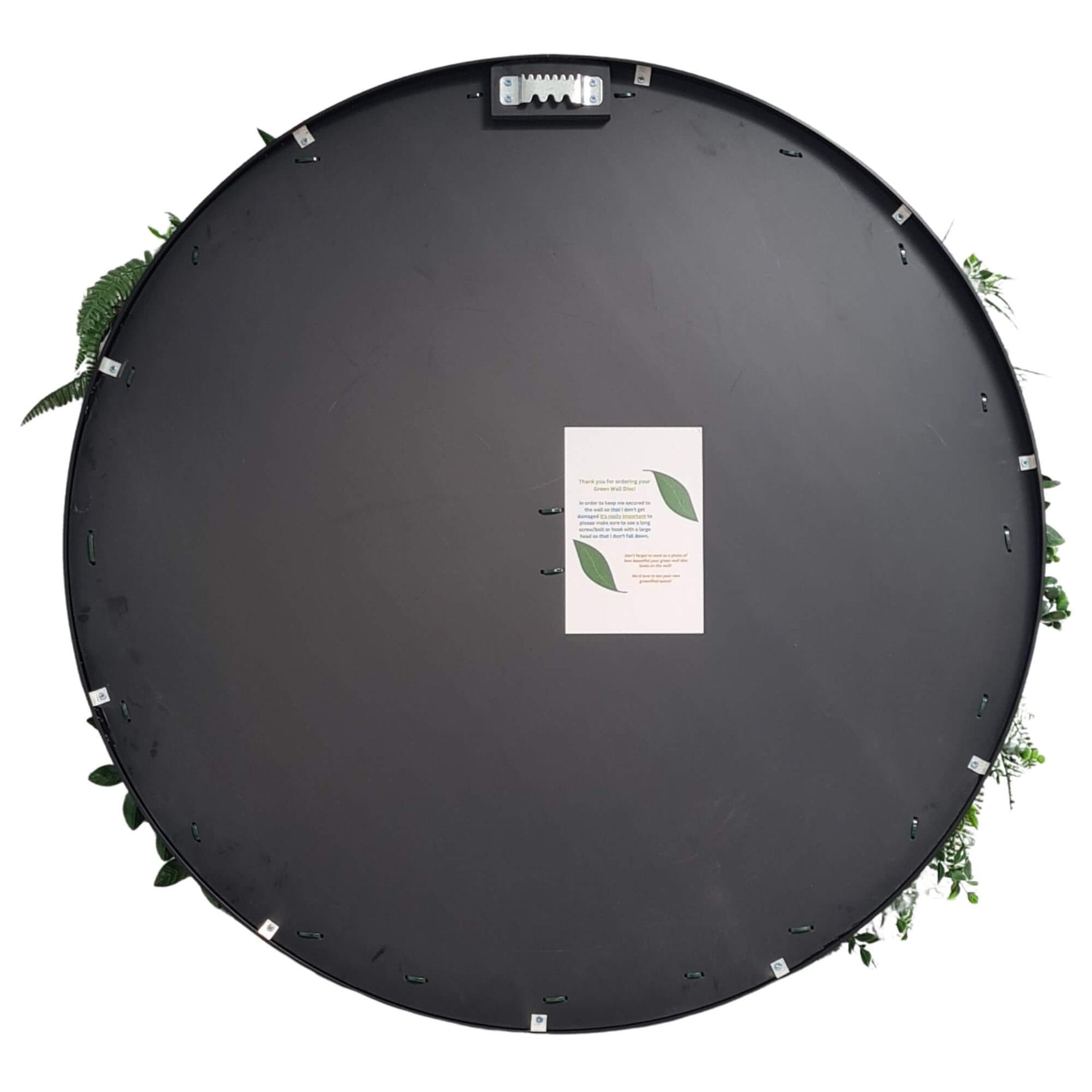 Round black mat with a central label surrounded by green leaves on a white background