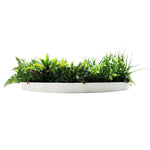 Artificial greenery in a white planter on a white background