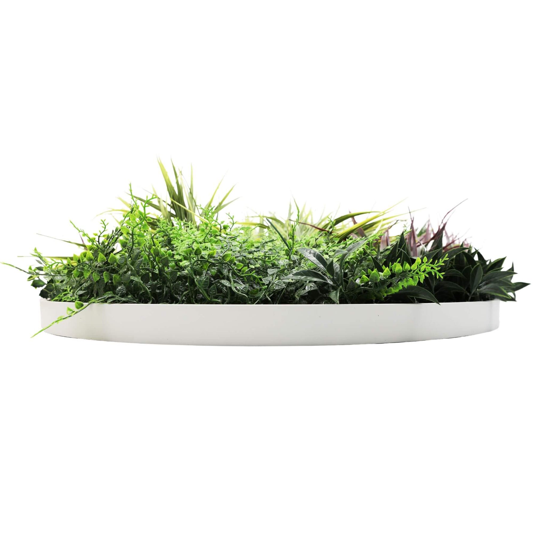 Artificial green plant arrangement in a white planter on a white background