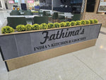 Fathima's India Kitchen & Grocery counter with green plants in a mall setting