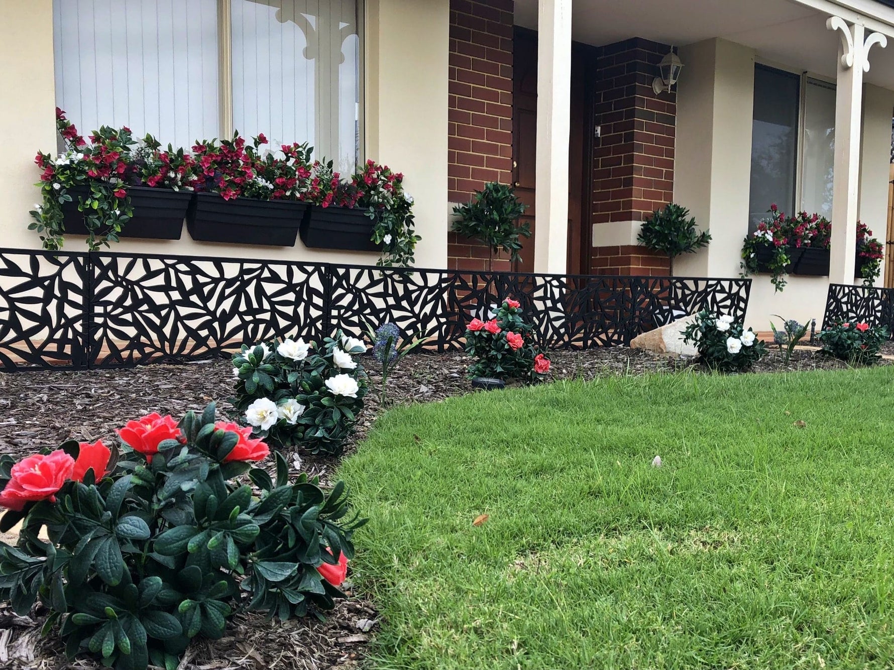 Lush garden with flowers and decorative elements in front of a house.