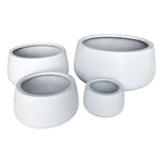 Set of four white stone-look planters on a white background